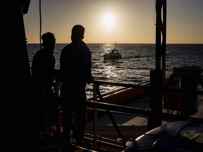 Deux migrants regardent le soleil se lever sur le pont du Sea Watch le 31 janvier 2019 - FEDERICO SCOPPA [AFP]