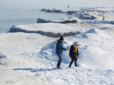 Des promeneurs sur les berges gelées du lac Michigan où les températures sont tombées à -29°C, le 30 janvier 2019 à Chicago - JOSHUA LOTT [AFP]