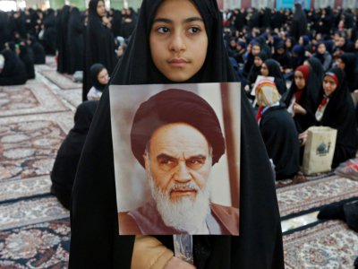 Une jeune Iranienne tient un portrait de l'imam Khomeiny à Téhéran le 1er février 2019 - STR [afp/AFP]