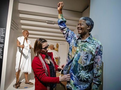 Une employée du musée Grévin habille la statue de Nelson Mandela - Thomas SAMSON [AFP]