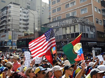 Un drapeau américain brandi par des partisans du chef de l'opposition vénézuélienne Juan Guaido qui se rassemblent le 12 février 2019 dans l'est de Caracas pour faire pression sur l'armée afin qu'elle laisse entrer l'aide humanitaire américaine - Federico PARRA [AFP]