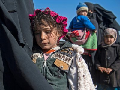 Des femmes et des enfants dans un champ près de Baghouz, dans l'est de la Syrie, après avoir fui le dernier bastion du groupe Etat islamique, le 12 février 2019 - Fadel SENNA [AFP/Archives]