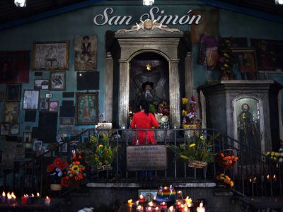 Une femme prie devant la statue de San Simon dans le village de San Andres Itzapa, le 6 février 2019 au Guatemala - Johan ORDONEZ [AFP]