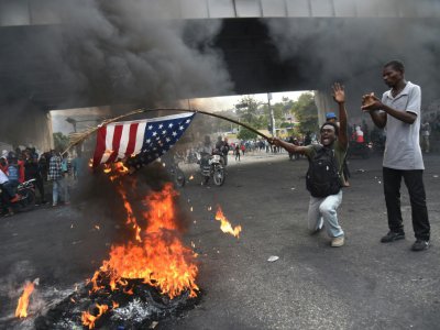 Des manifestants brûlent un drapeau américain, le 15 février 2019 à Port-au-Prince, en Haïti - HECTOR RETAMAL [AFP]