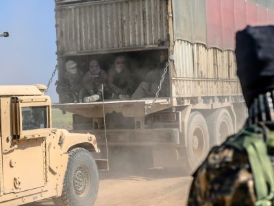 Des combattants du groupe Etat islamique qui se sont rendus aux Forces démocratiques syriennes (FDS), sont transportés en camioin hors de Baghouz, le 20 février 2019 - Bulent KILIC [AFP]
