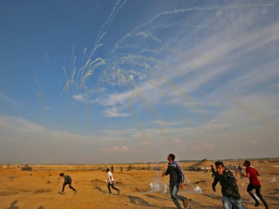 Des Palestiniens fuient pour éviter les tirs de gaz lacrymogènes des forces israéliennes, à Gaza, le 9 novembre 2018 - SAID KHATIB [AFP]