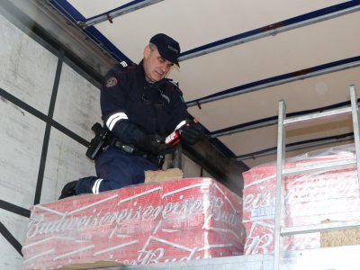 Un douanier contrôle la cargaison d'un camion qui transporte de la bière. - Pierre Durand-Gratian