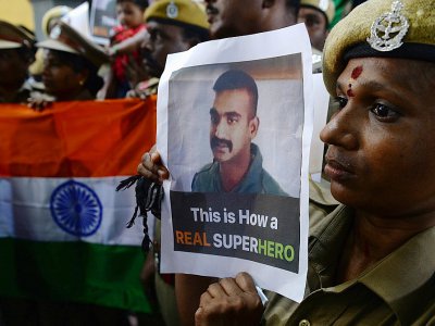 Un membre des forces de sécurité indiennes pose avec le portrait du lieutenant-colonel Abhinandan Varthamandu, capturé par l'armée pakistanaise, le 1er mars 2019 à Chennai - ARUN SANKAR [AFP]