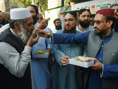 Des Pakistanais s'offrent des friandises pour fêter la capture d'un pilote de l'armée de l'air indienne, le 27 février 2019 à Karachi - RIZWAN TABASSUM [AFP]