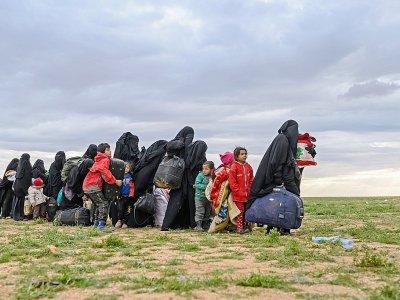 Des femmes et des enfants attendent d'être fouillés par les combattants des Forces démocratiques syriennes, après avoir quitté le dernier réduit du groupe Etat islamique à Baghouz, dans l'est de la Syrie, le 27 février 2019 - Bulent KILIC [AFP]
