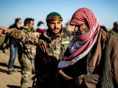 Un homme soupçonné d'être un combattant du groupe Etat islamique attend d'être fouillé par les combattants des Forces démocratiques syriennes, après avoir quitté le dernier réduit de l'EI à Baghouz, dans l'est de la Syrie, le 1er mars 2019 - Delil SOULEIMAN [AFP]