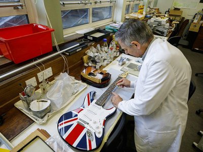 Peter Gasson, spécialiste de l'étude du bois dans le laboratoire de Kew (Londres), prélève un échantillon de bois sur un manche de guitare, le 19 février 2019 - TOLGA AKMEN [AFP]