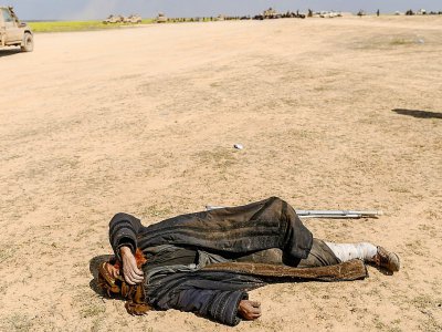 Un blessé soupçonné d'avoir combattu dans les rangs du groupe Etat islamique (EI) est allongé à même le sol après avoir fui le dernier bastion de l'EI à Baghouz, dans l'est de la Syrie, le 6 mars 2019 - Bulent KILIC [AFP]