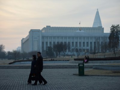 Des passants devant le siège de l'Assemblée suprême du peuple à Pyongyang, le 9 mars 2019 - Ed JONES [AFP]