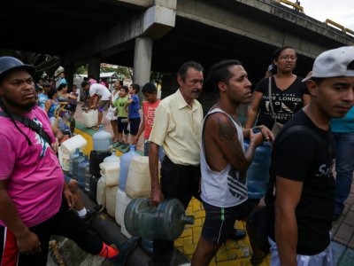 Des habitants font la queue pour s'approvisionner en eau potable, le 10 mars 2019 à Caracas - Cristian Hernandez [AFP]
