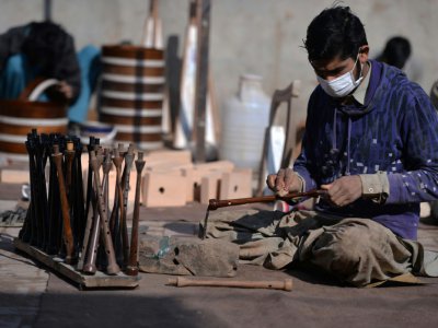 Un artisan fabrique des chanterelles, sortes de flûtes au son aigu dans lesquelles soufflent les joueurs de cornemuse, le 25 janvier 2019 à Sialkot au Pakistan - AAMIR QURESHI [AFP]