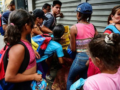 Des gens se battent pour récupérer de la nourriture sur le sol d'un marché de rue à Caracas, le 10 mars 2019 - RONALDO SCHEMIDT [AFP]
