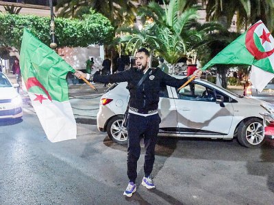 Un jeune Algérien manifeste sa joie dans le centre d'Alger le 11 mars 2019 après l'annonce du président Abdelaziz Bouteflika - RYAD KRAMDI [AFP]