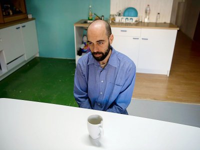 Hector Cabanol, un électricien espagnol de 36 ans, boit un café dans la cuisine commune de l'appartement-ruche illégal où il vit à Barcelone, le 22 février 2019 - Josep LAGO [AFP]