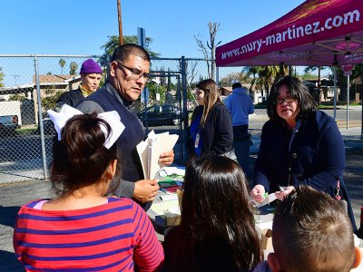 Le directeur de l'école Telfair, Jose Razo et ses élèves arrivent sur le site d'une distribution de matériel scolaire, le 8 février 2019 à Pacoima en Californie - Frederic J. BROWN [AFP]