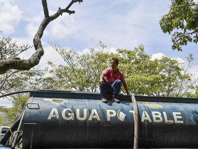 Un camion-citerne remplit d'eau potable en attente d'être distribuée après une panne d'électricité massive, le 13 mùars 2019 à Caracas, au Venezuela - YURI CORTEZ [AFP]