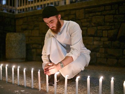 Un homme allume des bougies pour rendre hommage aux 49 victimes de l'attaque de deux mosquées à Christchurch, le 16 mars 2019 - Anthony WALLACE [AFP]