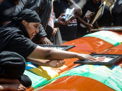 Une proche des victimes du crash touche un portrait sur un cercueil le 17 mars 2019 à Addis Abeba - Samuel HABTAB [AFP]