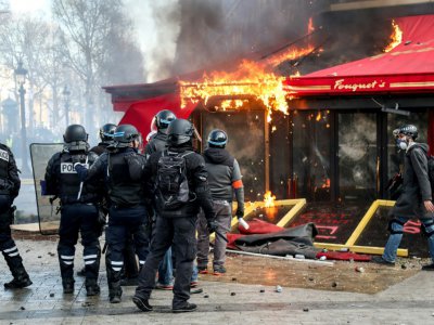 Les forces de police devant Le Fouquet's en feu, sur les Champs Elysées, à Paris, le 16 mars 2019 - Zakaria ABDELKAFI [AFP/Archives]