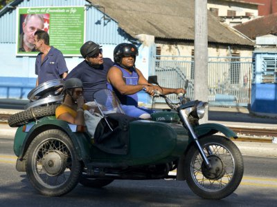 Un side-car transporte trois personnes à La Havane le 27 février 2019 - YAMIL LAGE [AFP]