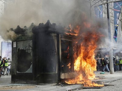 Un kiosque incendié sur les Champs-Elysées le 16 mars 2019 lors de l'acte 18 des "gilets jaunes". - Geoffroy VAN DER HASSELT [AFP]