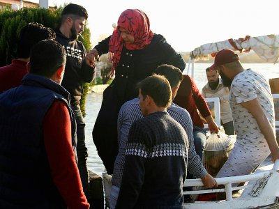 Une femme débarque d'un bateau, le 21 mars 2019 à Mossoul, en Irak - Waleed AL-KHALED [AFP]