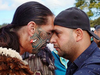 Un musulman (à droite) et un non-musulman pratiquent le "hongri", salutation traditionnelle maori, pendant la prière du vendredi devant la mosquée al-Nour de Christchurch, le 22 mars 2019 - Jerome TAYLOR [AFP]