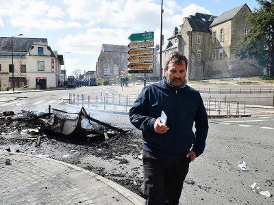 Norman Bruch, président du syndicat des forains Cidunati, près d'une carcasse de caravane brûlée dans le centre du Mans, le 25 mars 2019 - JEAN-FRANCOIS MONIER [AFP]