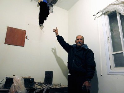 Un homme montre les dégats provoqués dans son domicile par une roquette tirée depuis la bande de Gaza, le 25 mars 2019 au soir, dans la ville israélienne de Sdérot - Ahmad GHARABLI [AFP]