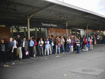 Des habitants attendent un moyen de transport à un arrêt de bus pendant la panne de courant entraînant la fermeture du métro, dans le quartier de Petare à Caracas, le 26 mars 2019 - Yuri CORTEZ [AFP]