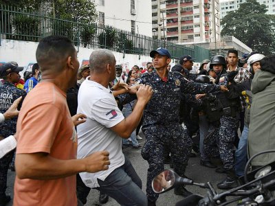 Des policiers vénézuéliens tentent d'éviter une confrontation entre partisans du président Nicolas Maduro et de l'opposant Juan Guaido, le 29 mars 2019 à Caracas - YURI CORTEZ [AFP]