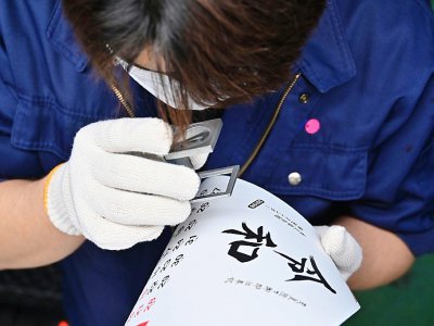Un employé de l'imprimeur Todan travaille sur les idéogrammes de la nouvelle ère "Reiwa", dans l'usine de l'imprimeur à Ibaraki, le 1er avril 2019 - CHARLY TRIBALLEAU [AFP]