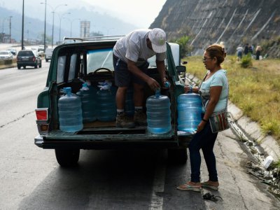 Des habitants du quartier Petare chargent des bidons d'eau dans une camionnette, le 1er avril 2019 à Caracas, au Venezuela - FEDERICO PARRA, FEDERICO PARRA [AFP]