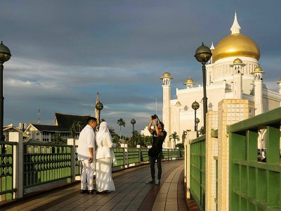Un couple de jeunes mariés se fait photographier le 1er avril 2019 à la mosquée Sultan Omar Ali Saifuddien de Bandar Seri Begawan, la capitale du sultanat de Brunei - - [AFP]