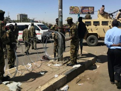 Des soldats soudanais installent du fil barbelé près du QG de l'armée dans la capitale Khartoum, où sont rassemblés des milliers de manifestants venus réclamer la démission du président Omar el-Béchir, le 7 avril 2019 - - [AFP]