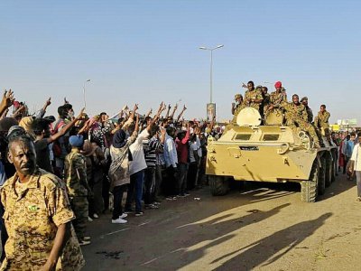 Des manifestants soudanais font le signe de la victoire en direction de militaires de l'armée à Khartoum, le 7 avril 2019 - - [AFP]