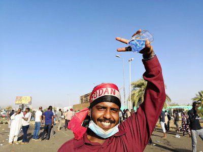 Un manifestant soudanais fait le signe de la victoire près du QG de l'armée à Khartoum, le 9 avril 2019 - STRINGER [AFP]