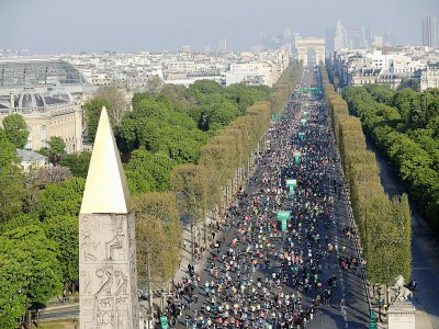 Les athlètes empruntent la célèbre avenue des Champs Elysées lors du marathon de Paris, le 14 avril 2019 - Thomas SAMSON [AFP]