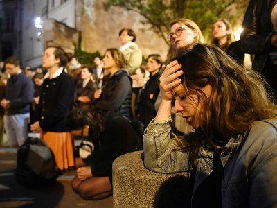 Parisiens et touristes chantant et priant pendant que Notre Dame est en flammes, à Paris, le 15 avril 2019 - ERIC FEFERBERG [AFP]