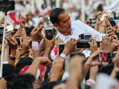 Le président Joko Widodo pose pour des selfies durant un meeting électoral à Jakarta le 13 avril 2019 - BAY ISMOYO [AFP/Archives]