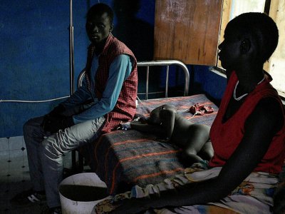 Un couple attend d'être reçu avec son enfant malade au centre de soins du CICR à Udier, au Soudan du Sud, le 7 mars 2019 - SIMON MAINA [AFP]