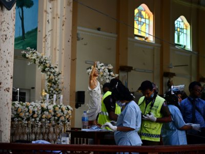 Du personnel de sécurité relèvent des traces dans l'église Saint-Sebastien de Negombo, le 22 avril 2019 au lendemain des explosions meurtrières - Jewel SAMAD [AFP]