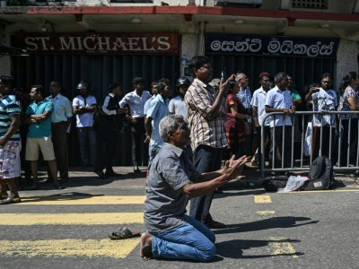 Des gens prient devant l'église Saint-Antoine, à Colombo, le 22 avril 2019, au lendemain d'une série d'explosions meurtrières - Mohd RASFAN [AFP]