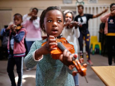 Une enfant joue du violon pendant une leçon donnée à l'école de musique Buskaid, le 13 avril 2019 dans le township de Soweto, en Afrique du Sud - WIKUS DE WET [AFP/Archives]