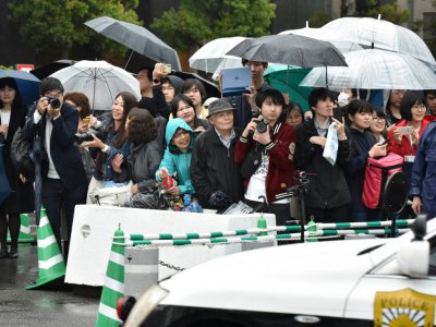 Des passants attendent la famille impériale devant le palais impérial de Tokyo, le 30 avril 2019 - Kazuhiro NOGI [AFP]
